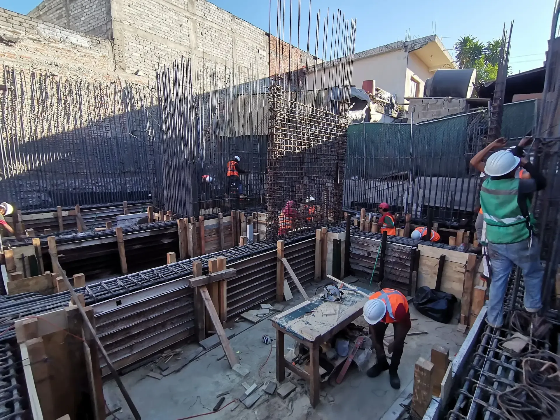 Ingenieros supervisando obra negra con castillos de cimentación